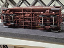 Undercarriage view of brown model caboose trucks and coupler details