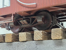 Caboose wheel and undercarriage detail with wooden blocks on display.